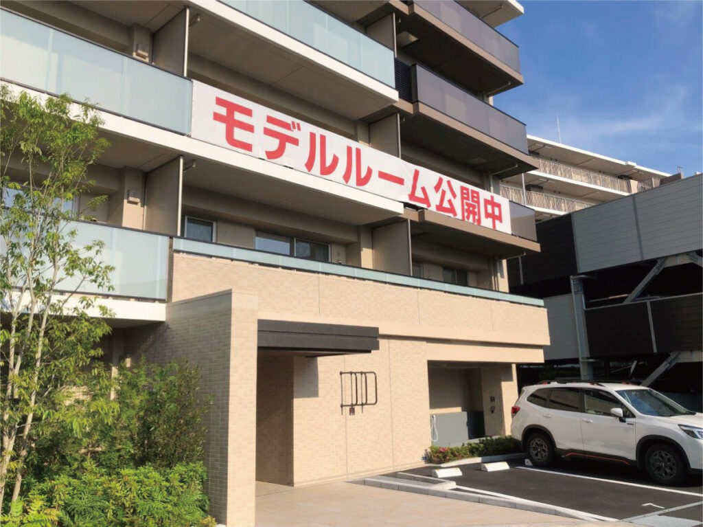 マンションのバルコニーに懸垂幕が設置された完了後の状態。遠くからも視認性の高い広告掲出の様子